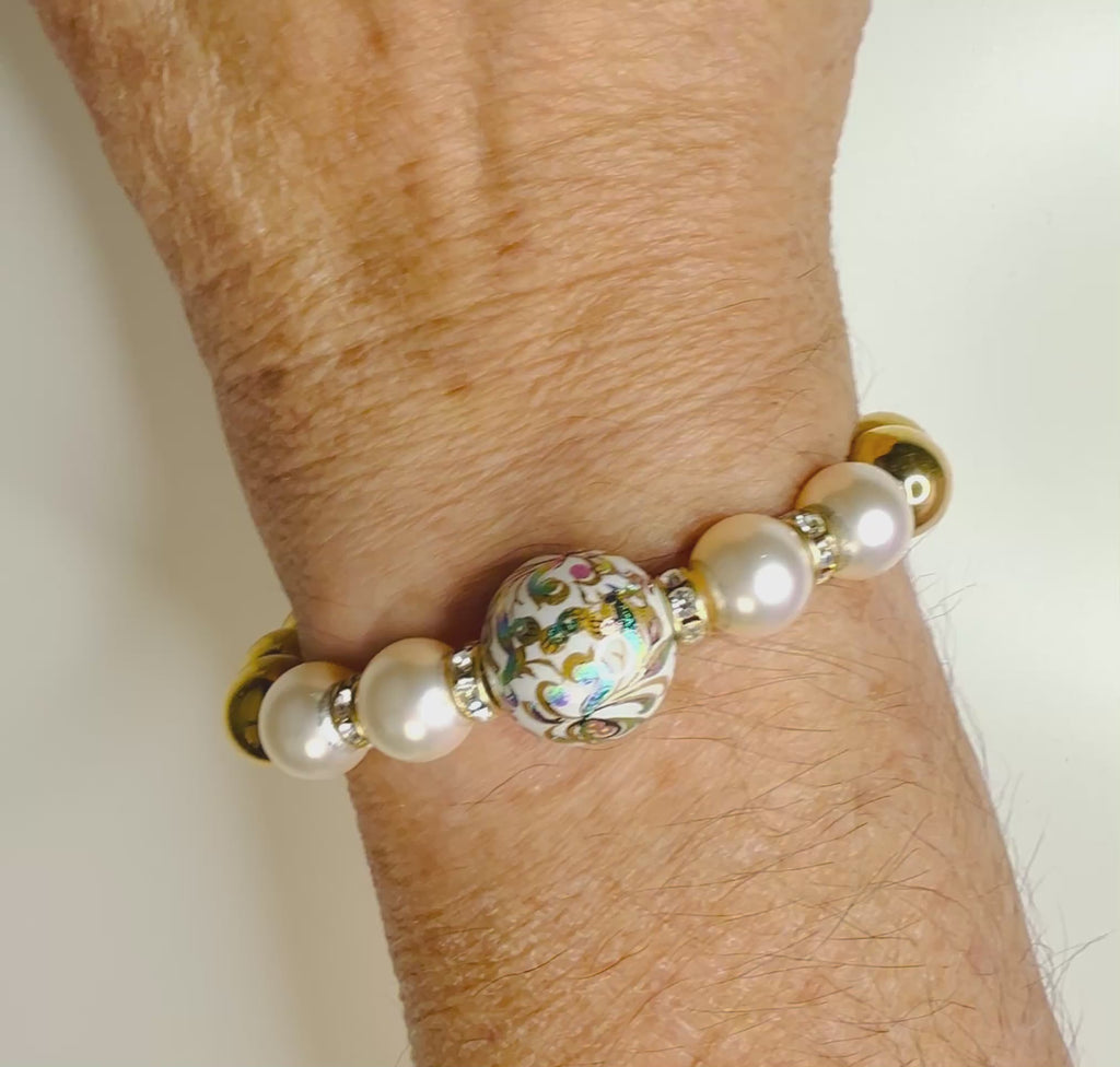 Imperial Blossom Stretch Bracelet worn on wrist, featuring a rare Japanese Tensha bead with floral artwork, Austrian Crystal cream rose pearls, sparkling rondelles, and gold-plated hematite. Handcrafted in Canada by Carabella by Cheryl.