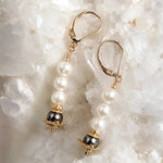 Serenity Swarovski® Crystal Pearl earrings with dark grey accent pearls and 14k gold-filled leverback ear wires displayed on a white quartz crystal cluster