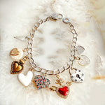 Esme charm bracelet styled flat lay showcasing multi-metal heart charms for everyday luxury wear.
