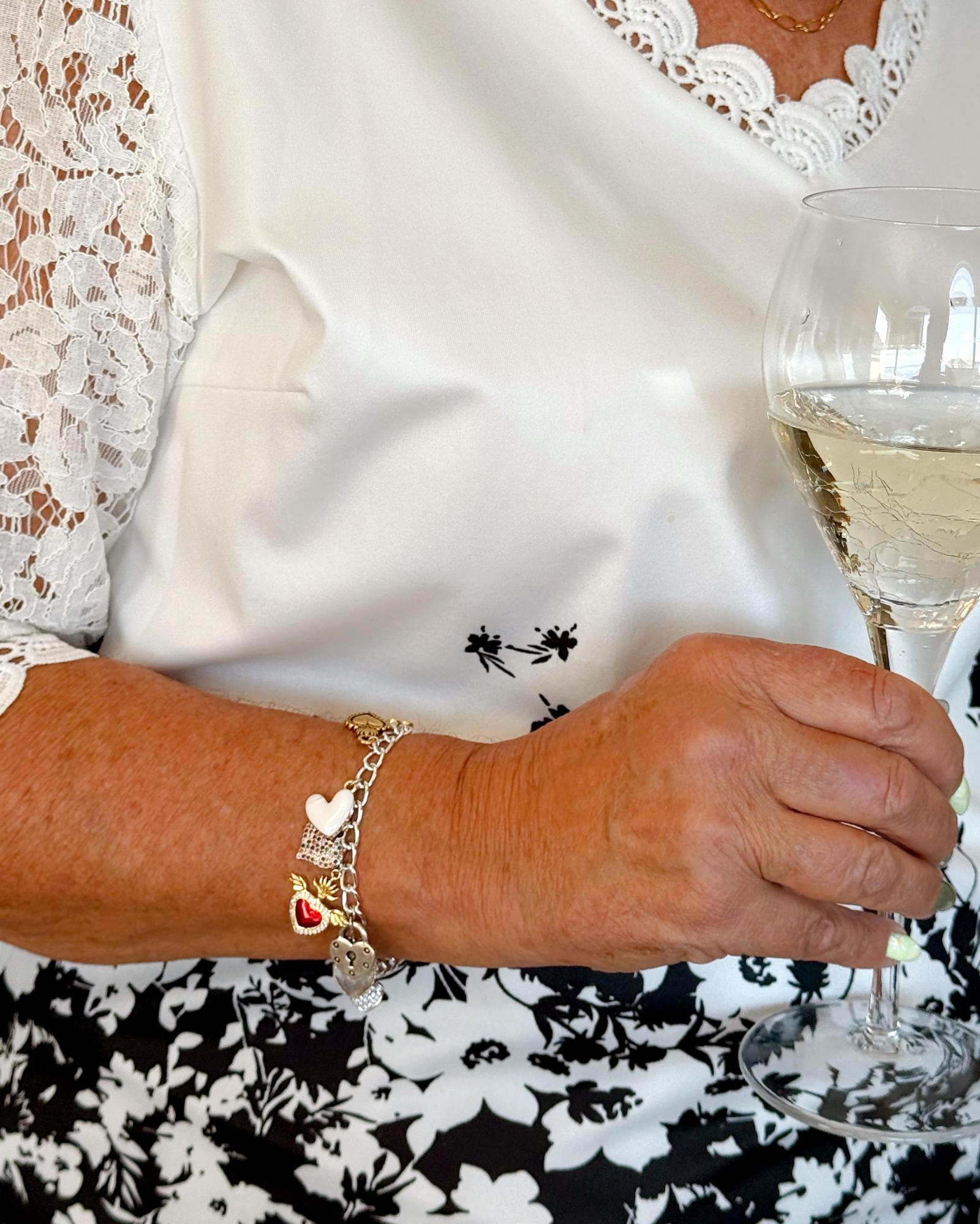 Esme charm bracelet in sterling silver-plated finish with heart charms and pavé clasp.