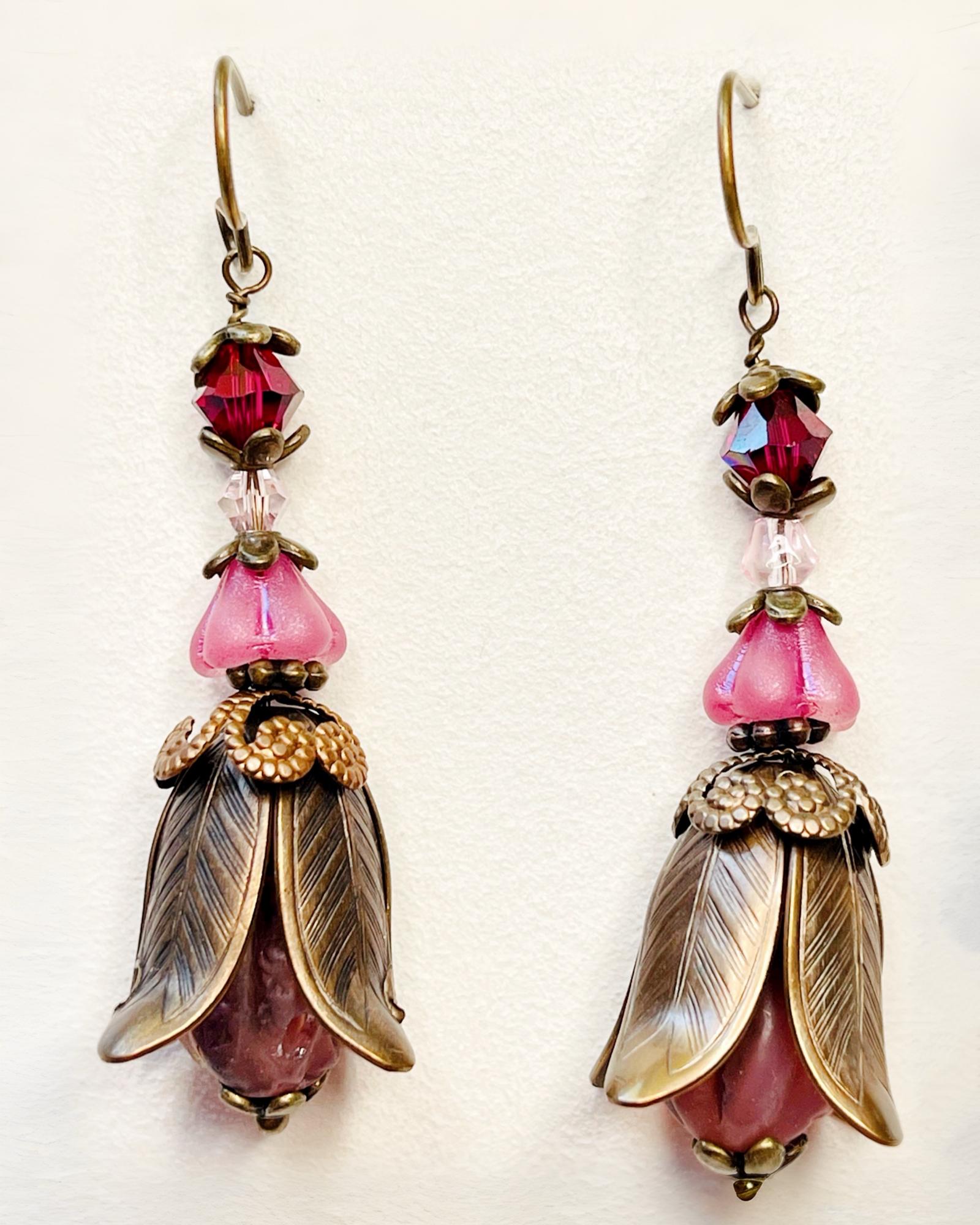 Close-up of Tulipe Garden Reverie Earrings featuring layered brass petals, pink glass flowers, and deep berry Austrian crystals — handmade by Carabella by Cheryl.