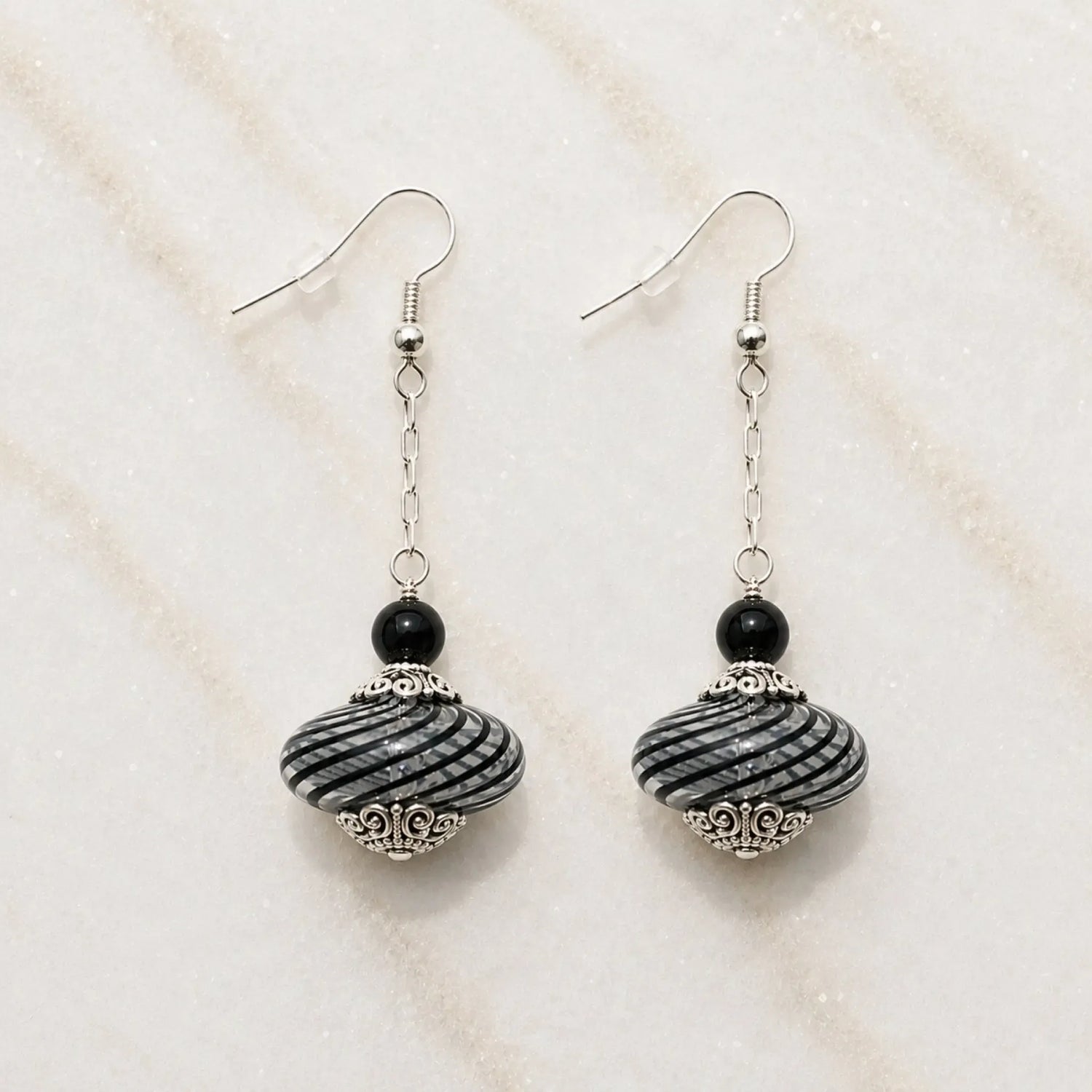 Venezia handcrafted Murano glass drop earrings with sterling silver on Carabella white quartz background.