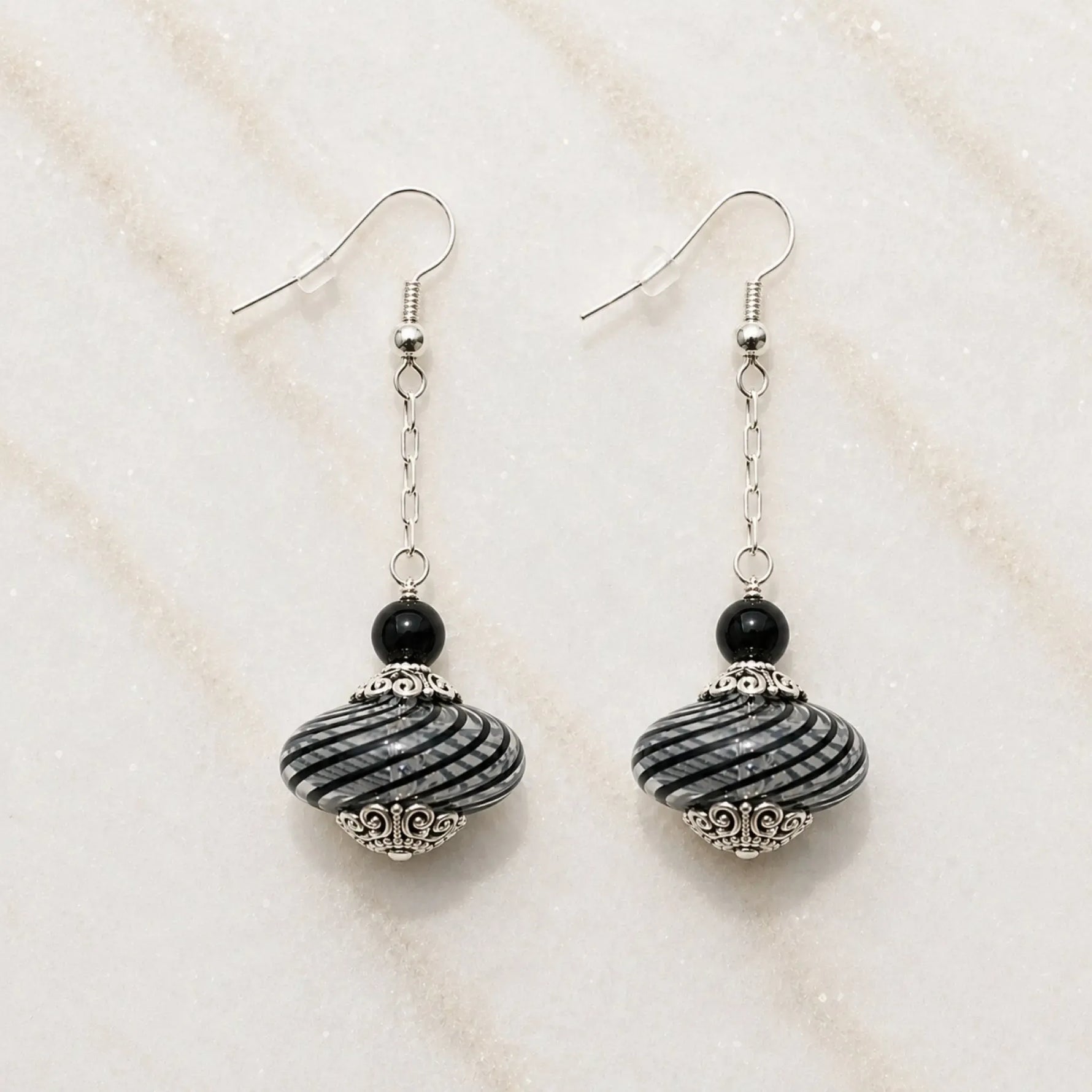 Venezia handcrafted Murano glass drop earrings with sterling silver on Carabella white quartz background.