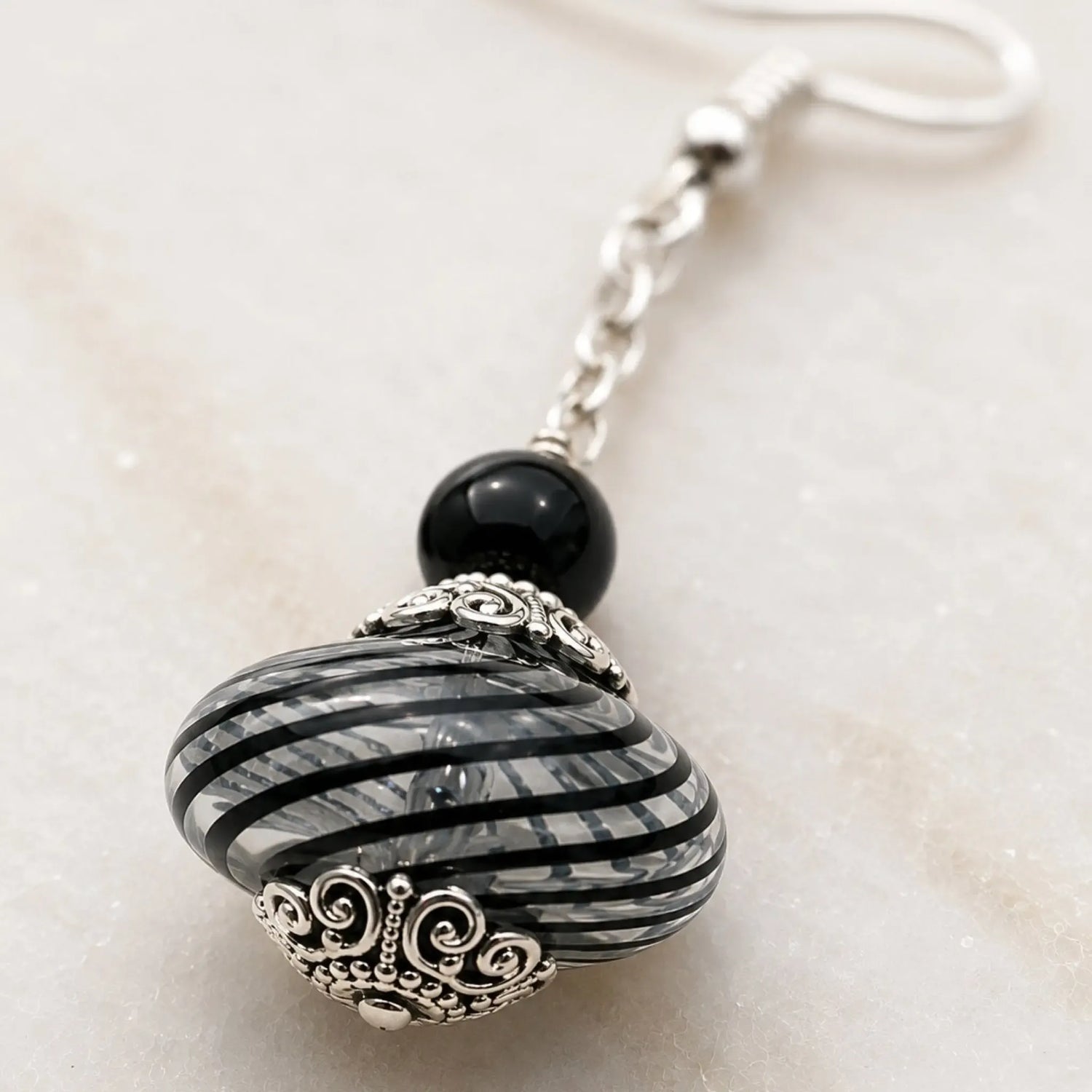 Close-up of Venezia Murano glass drop earring highlighting handcrafted striped glass, sterling silver bead caps and artisan details.