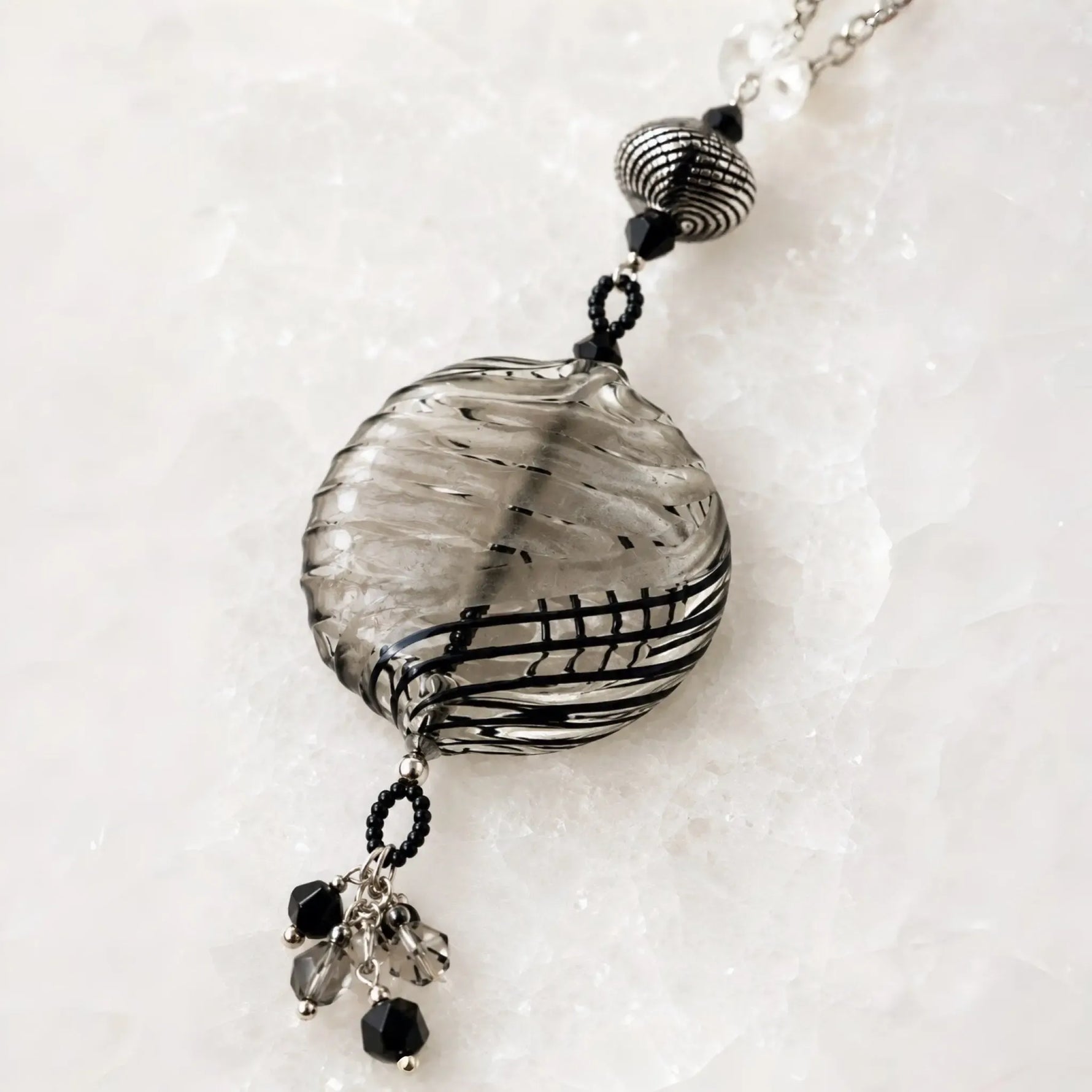Close-up of the handcrafted Venezia Murano glass pendant showing authentic Venetian glass artistry, sterling silver components and crystal tassel detail.