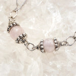 Macro detail of the Venus Bracelet highlighting rose quartz and moonstone gemstones, sterling silver bead caps, and handcrafted craftsmanship.