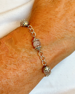 Model wearing the Venus Rose Quartz Bracelet, showcasing rose quartz gemstones, pewter bead caps, and silver-plated curb chain with heart-shaped clasp. Handcrafted in Canada by Carabella by Cheryl.