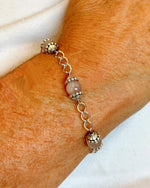 Model wearing the Venus Rose Quartz Bracelet, showcasing rose quartz gemstones, pewter bead caps, and silver-plated curb chain with heart-shaped clasp. Handcrafted in Canada by Carabella by Cheryl.