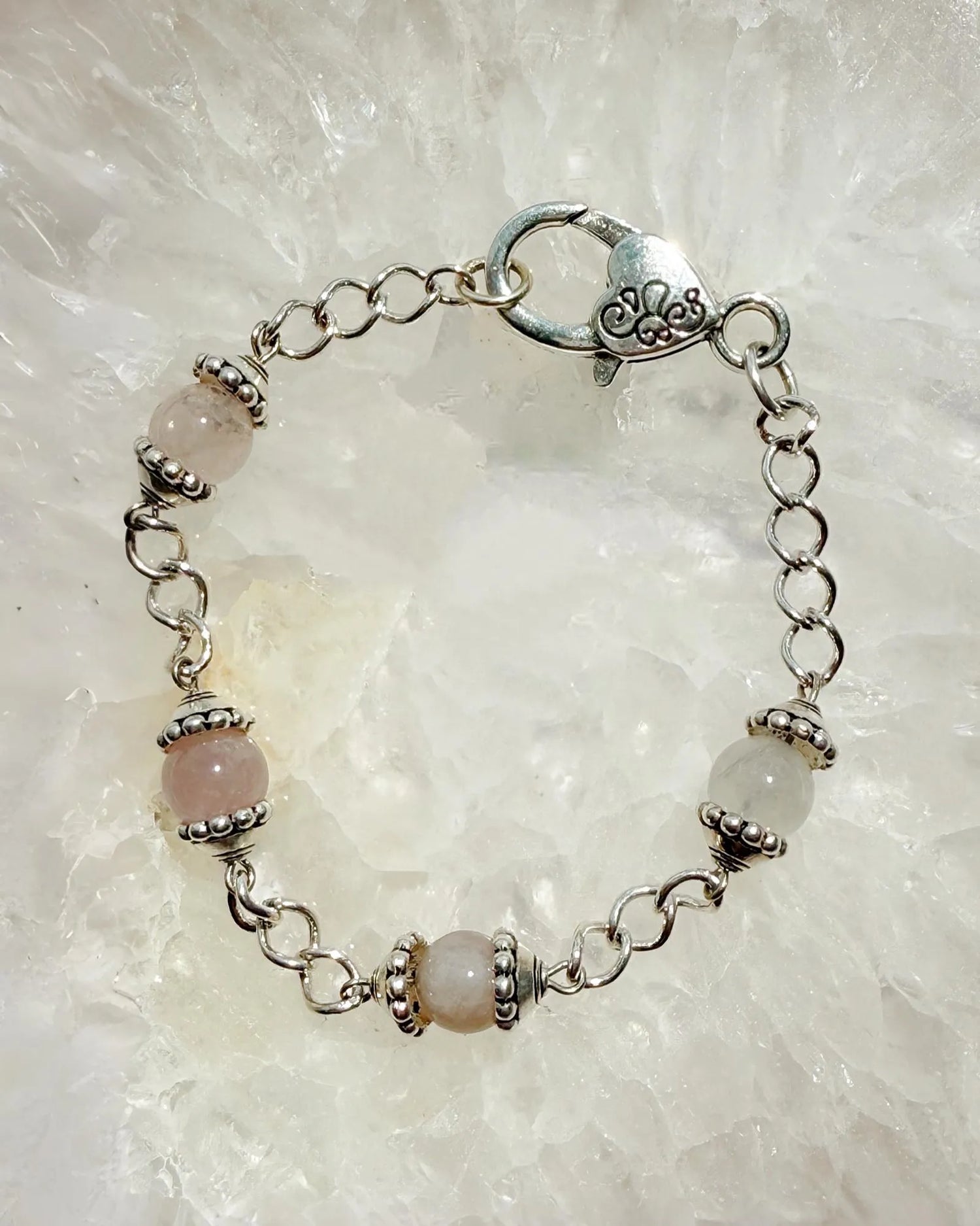 Close-up of the Venus Rose Quartz Bracelet featuring natural rose quartz gemstones, pewter bead caps, and a silver-plated curb chain with a heart clasp. Handcrafted in Canada by Carabella by Cheryl.