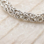 Close-up of the handcrafted Byzantine weave in the Zoe sterling silver bracelet showing the intricate interlocking rings and polished finish.