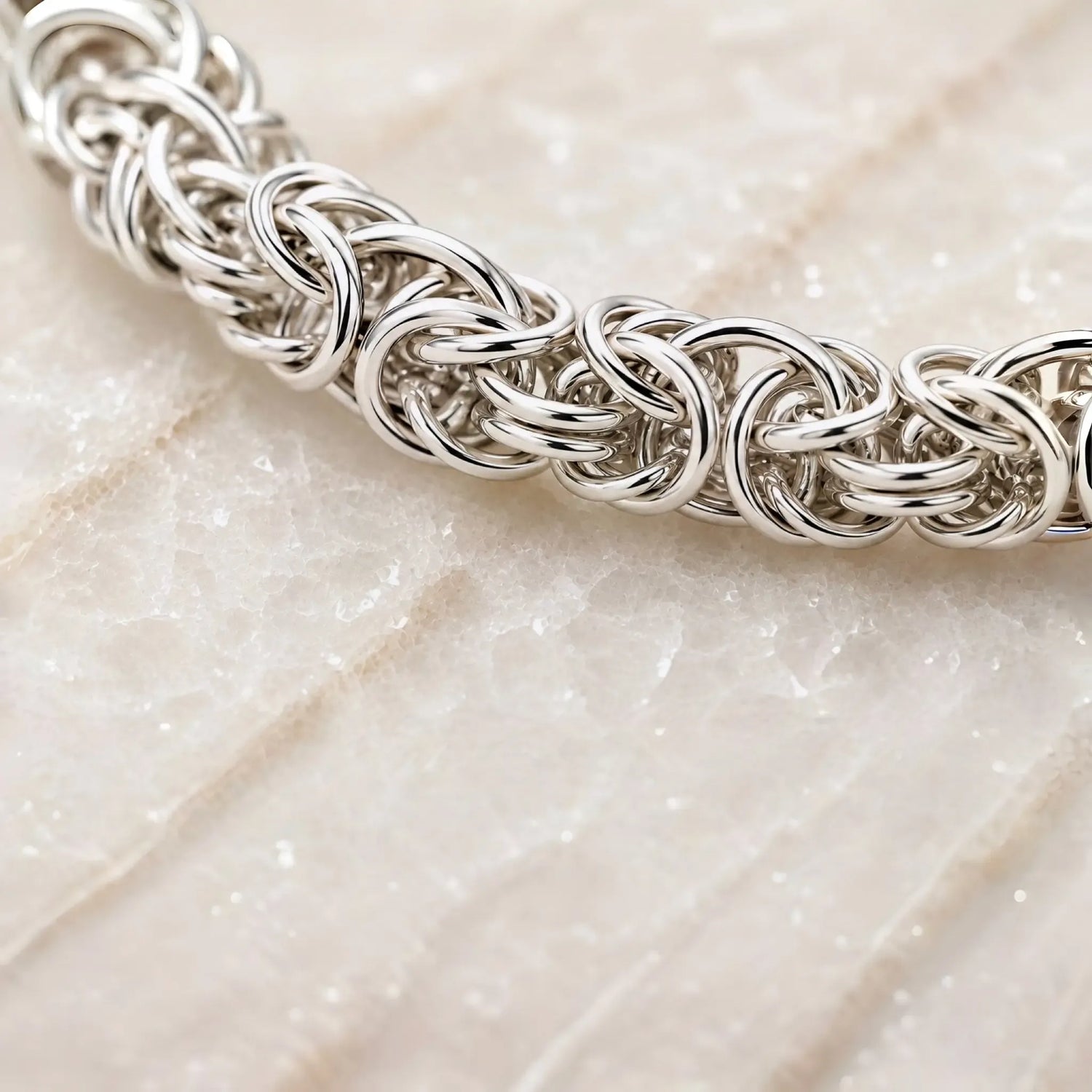 Close-up of the handcrafted Byzantine weave in the Zoe sterling silver bracelet showing the intricate interlocking rings and polished finish.