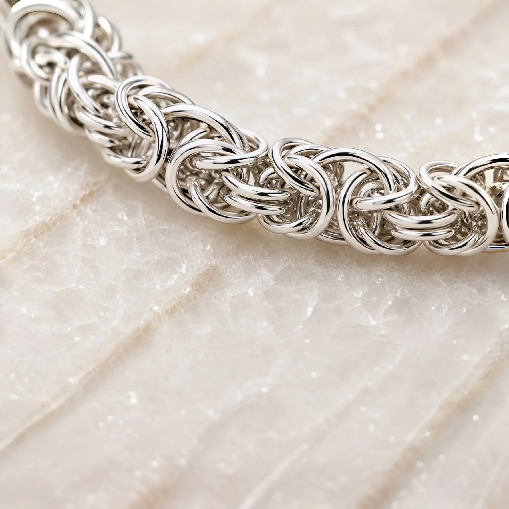 Close-up of the handcrafted Byzantine weave in the Zoe sterling silver bracelet showing the intricate interlocking rings and polished finish.